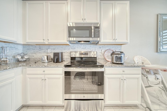 kitchen featuring tasteful backsplash, light stone countertops, and stainless steel appliances