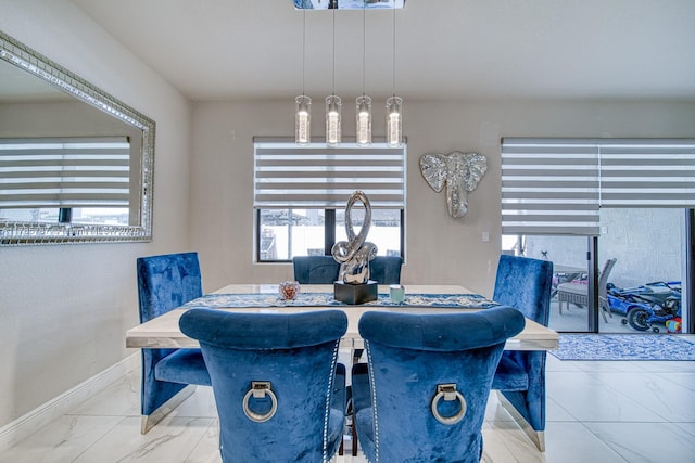 dining area featuring baseboards and marble finish floor