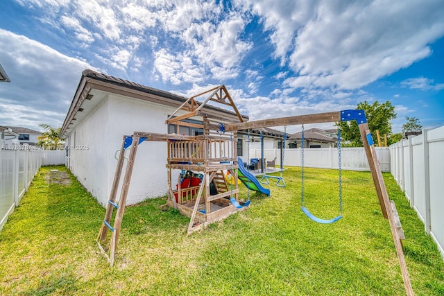 rear view of property with a playground, a lawn, and a fenced backyard