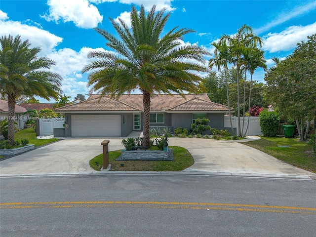 single story home featuring fence, a tiled roof, an attached garage, and concrete driveway
