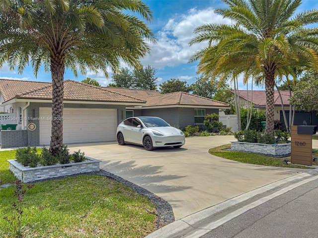 single story home with driveway, fence, an attached garage, and a tile roof