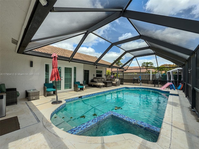 view of swimming pool with a patio, a pool with connected hot tub, outdoor lounge area, a ceiling fan, and french doors