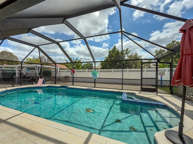 view of swimming pool featuring a patio, glass enclosure, and a fenced backyard