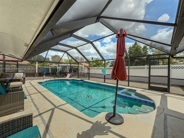 view of swimming pool featuring a pool with connected hot tub, a patio, a fenced backyard, and a lanai