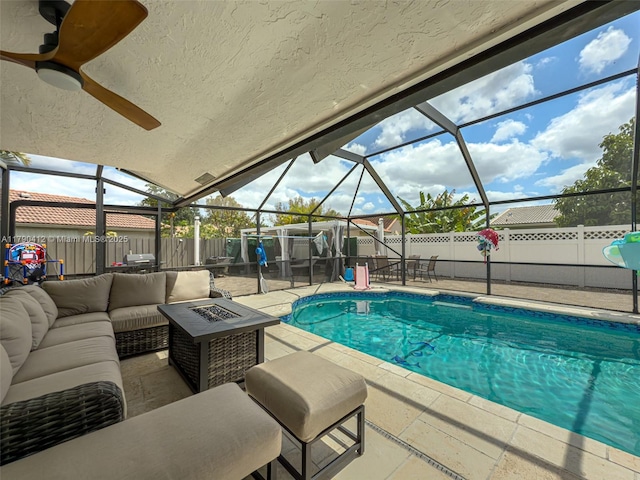 view of swimming pool with glass enclosure, a fenced backyard, an outdoor living space with a fire pit, and a patio area