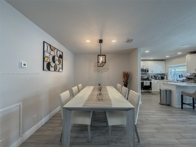 dining room featuring recessed lighting, a textured ceiling, and visible vents