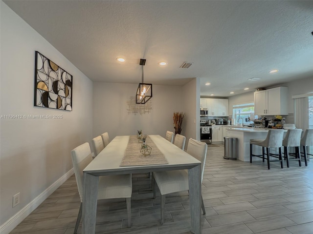 dining space with recessed lighting, an inviting chandelier, baseboards, visible vents, and a textured ceiling
