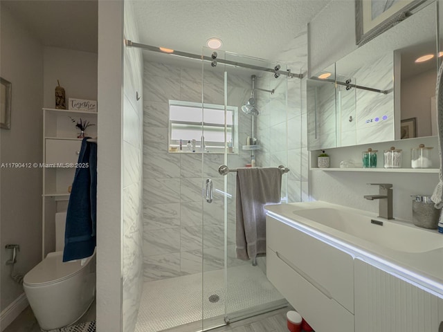 full bathroom with toilet, a stall shower, a textured ceiling, and vanity