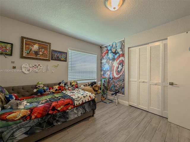 bedroom featuring a textured ceiling, a closet, and wood finished floors