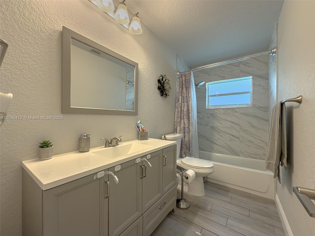 full bath with shower / bath combo, vanity, toilet, and a textured wall