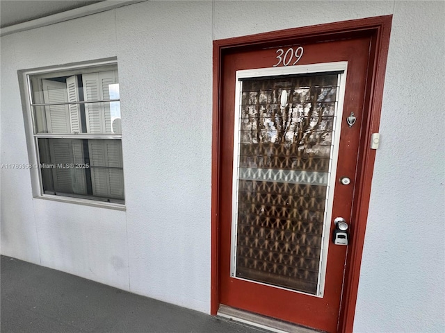 entrance to property with stucco siding