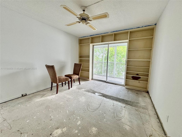 living area featuring a ceiling fan and a textured ceiling