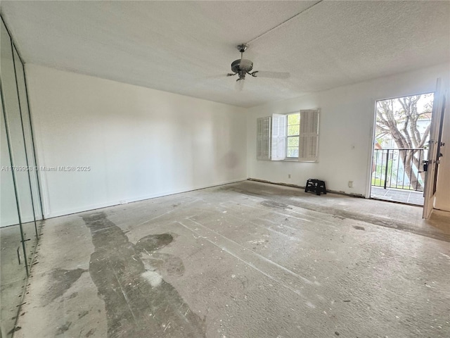 spare room with a textured ceiling, a ceiling fan, and baseboards
