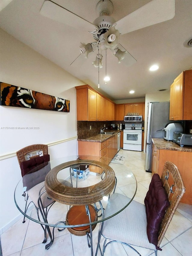 21338 Juego Cir Unit 11C, Boca Raton, FL 33433 - kitchen with stainless steel appliances, ceiling fan, a sink, backsplash, and light tile patterned flooring