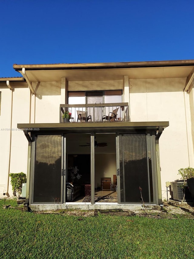 21338 Juego Cir Unit 11C, Boca Raton, FL 33433 - back of property featuring a balcony, stucco siding, a sunroom, and a lawn