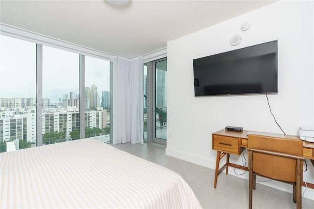 bedroom featuring multiple windows, access to outside, a wall of windows, and baseboards