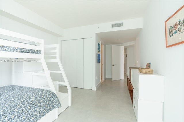 bedroom featuring a closet, visible vents, and concrete flooring