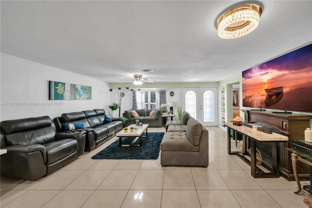 tiled living area featuring visible vents and ceiling fan with notable chandelier