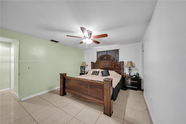 bedroom featuring light tile patterned flooring, visible vents, a ceiling fan, and baseboards