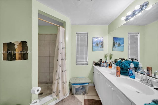 bathroom featuring tile patterned floors, a shower stall, double vanity, and a sink