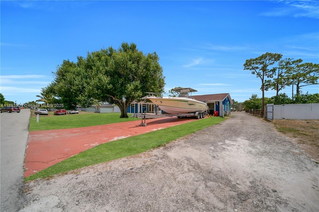view of front of home featuring fence, driveway, and a front yard