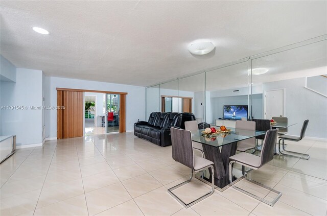 living area featuring light tile patterned floors, baseboards, a textured ceiling, and visible vents
