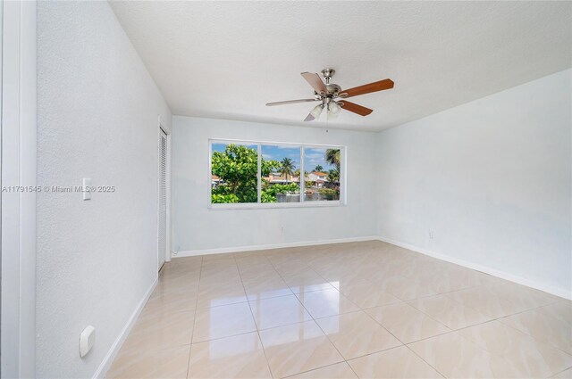 interior space featuring baseboards, ceiling fan, a textured ceiling, and visible vents