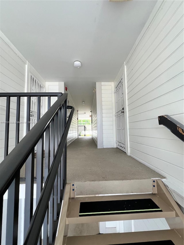 stairway featuring wood walls