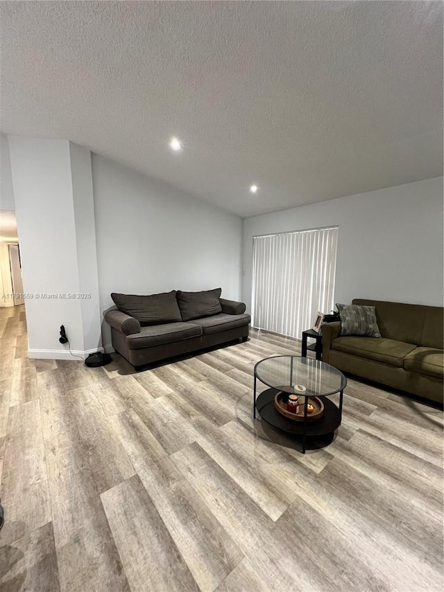living room featuring a textured ceiling, wood finished floors, recessed lighting, and baseboards