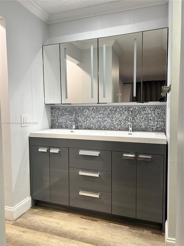 bathroom featuring double vanity, wood finished floors, decorative backsplash, and a sink