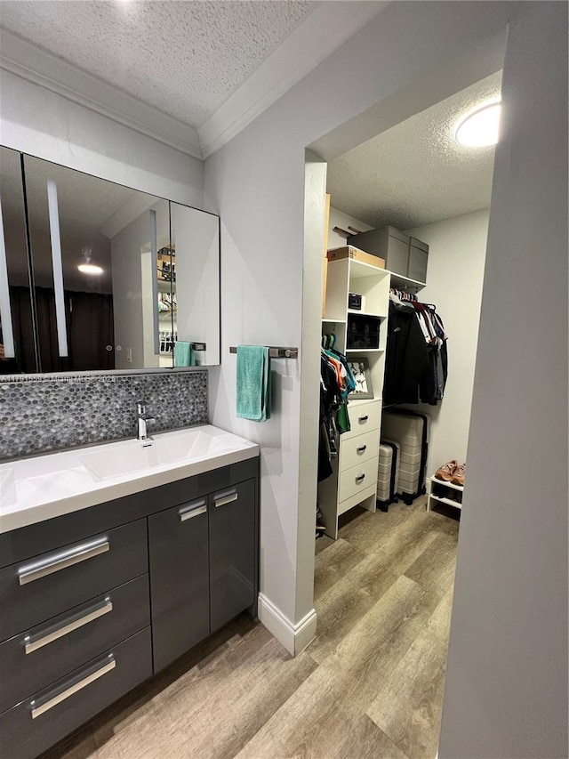 bathroom featuring tasteful backsplash, wood finished floors, and a textured ceiling