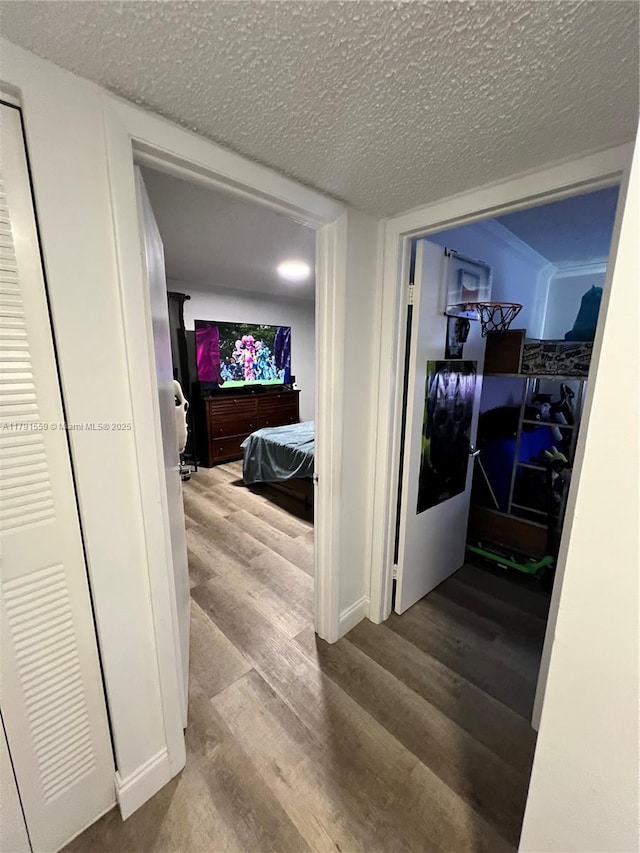 corridor featuring wood finished floors and a textured ceiling
