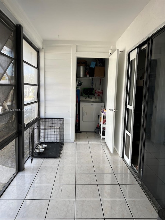 hall with light tile patterned floors and washer and clothes dryer