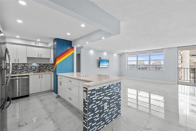 kitchen with open floor plan, stainless steel appliances, light countertops, and white cabinets