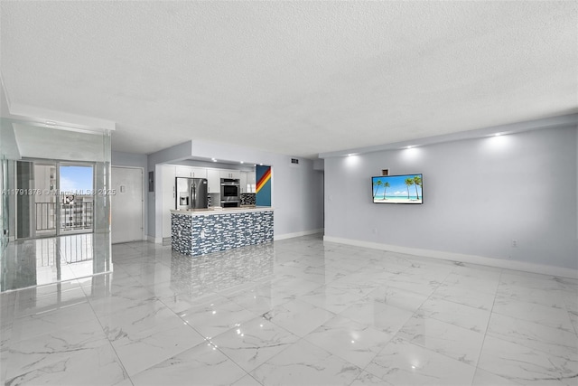 unfurnished living room featuring a textured ceiling, visible vents, marble finish floor, and baseboards