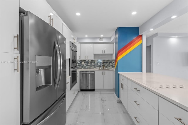kitchen with white cabinets, appliances with stainless steel finishes, light countertops, recessed lighting, and marble finish floor