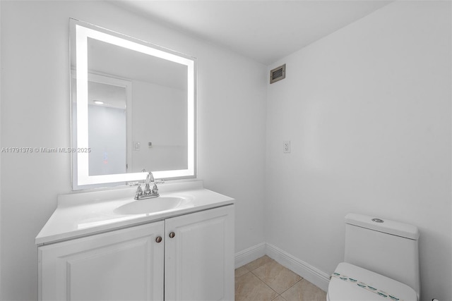 bathroom featuring vanity, toilet, visible vents, baseboards, and tile patterned flooring