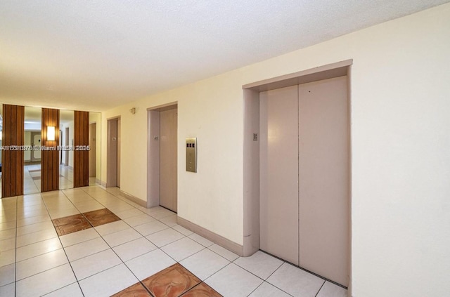corridor featuring light tile patterned floors and elevator