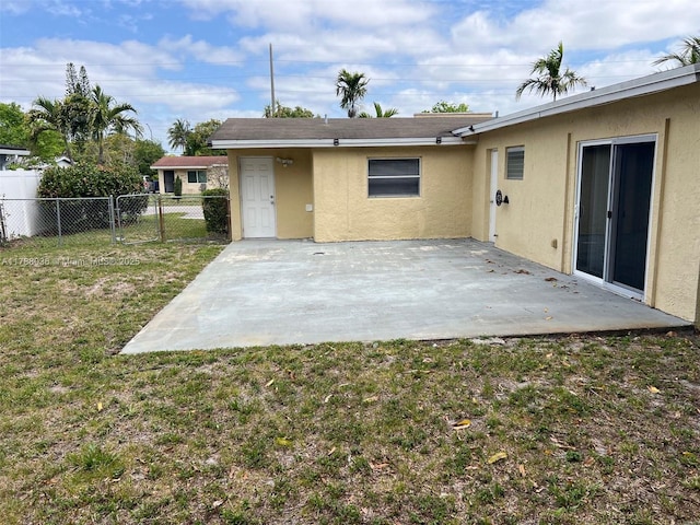 4410 NW 30th Ct, Lauderdale Lakes, FL 33313 - back of property featuring a patio, fence, stucco siding, and a lawn