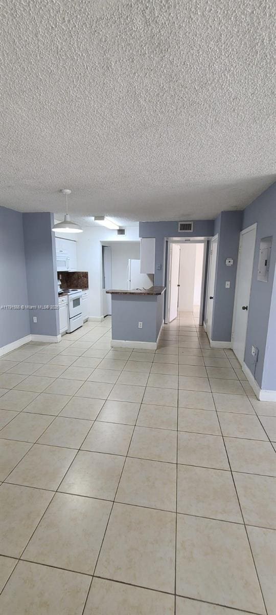 15231 SW 80th St Unit 209, Miami, FL 33193 - unfurnished living room featuring light tile patterned floors, a textured ceiling, visible vents, and baseboards