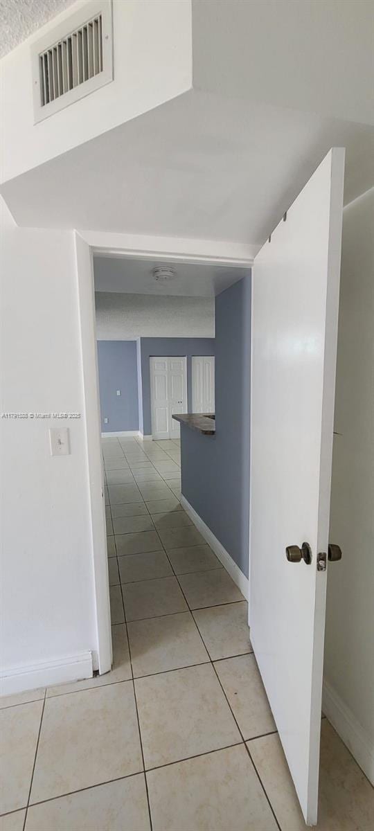15231 SW 80th St Unit 209, Miami, FL 33193 - hall featuring light tile patterned flooring, visible vents, and baseboards