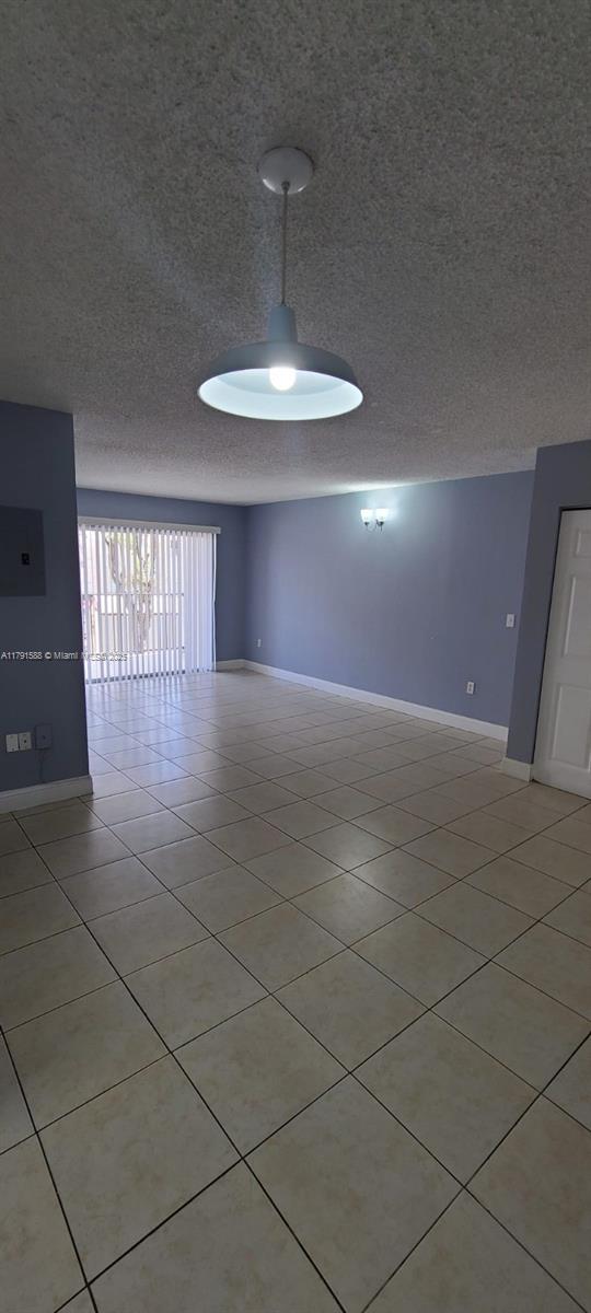 15231 SW 80th St Unit 209, Miami, FL 33193 - unfurnished room with baseboards, light tile patterned floors, and a textured ceiling