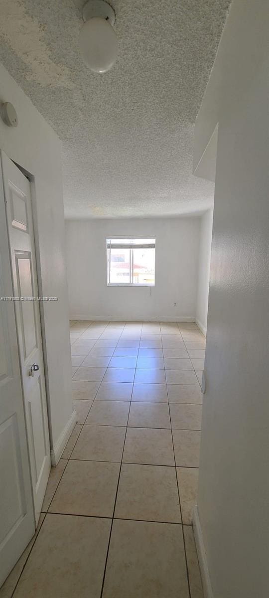 15231 SW 80th St Unit 209, Miami, FL 33193 - hall with light tile patterned floors, a textured ceiling, and baseboards