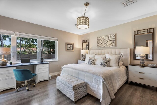 bedroom featuring dark wood-style floors, visible vents, and baseboards