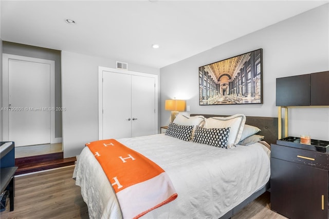 bedroom with recessed lighting, a closet, visible vents, and wood finished floors