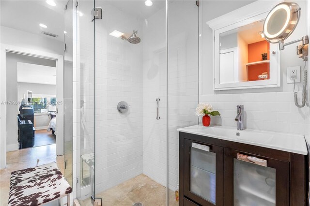 ensuite bathroom featuring tasteful backsplash, visible vents, a stall shower, vanity, and ensuite bath