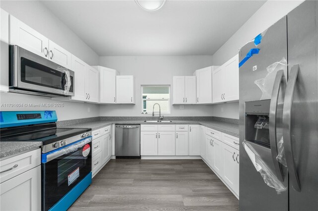 1429 Las Villas Blvd, Sebring, FL 33870 - kitchen with stainless steel appliances, white cabinets, and wood finished floors