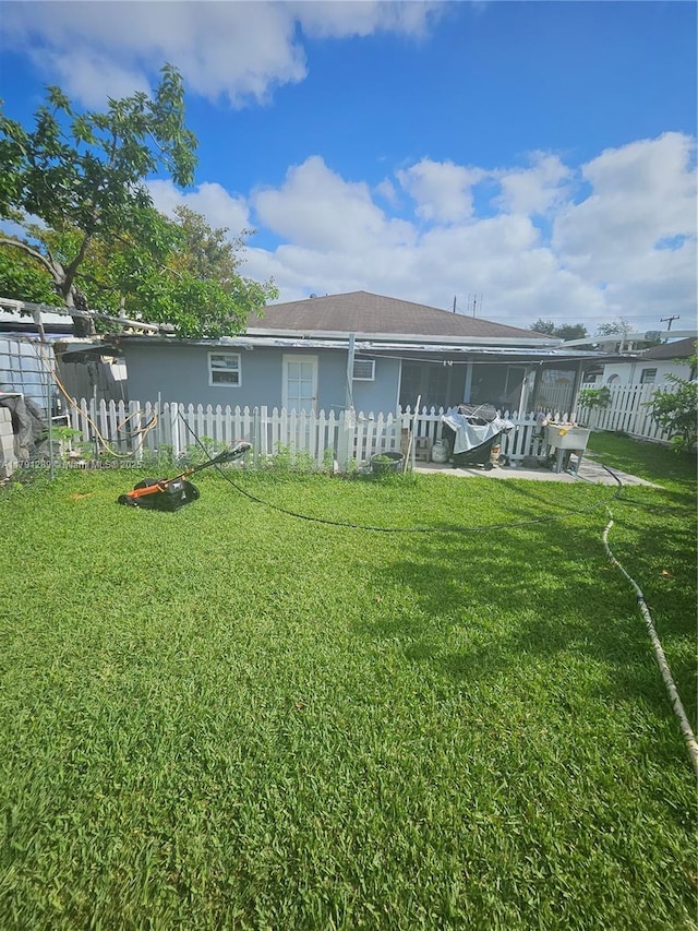 back of property featuring a lawn, fence, and a patio area