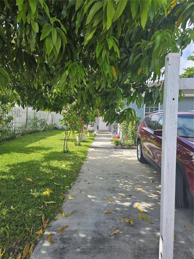 view of property's community with a lawn and fence