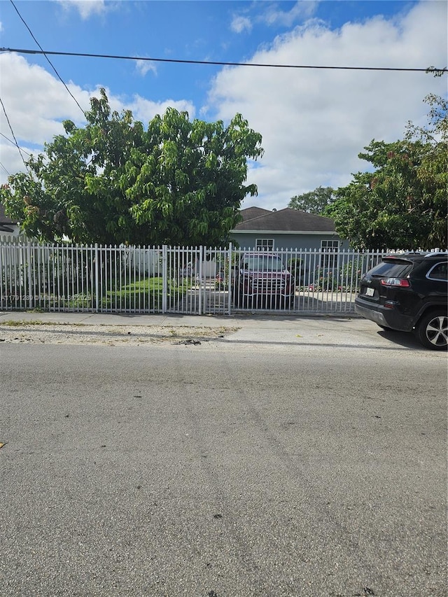 view of property hidden behind natural elements with fence